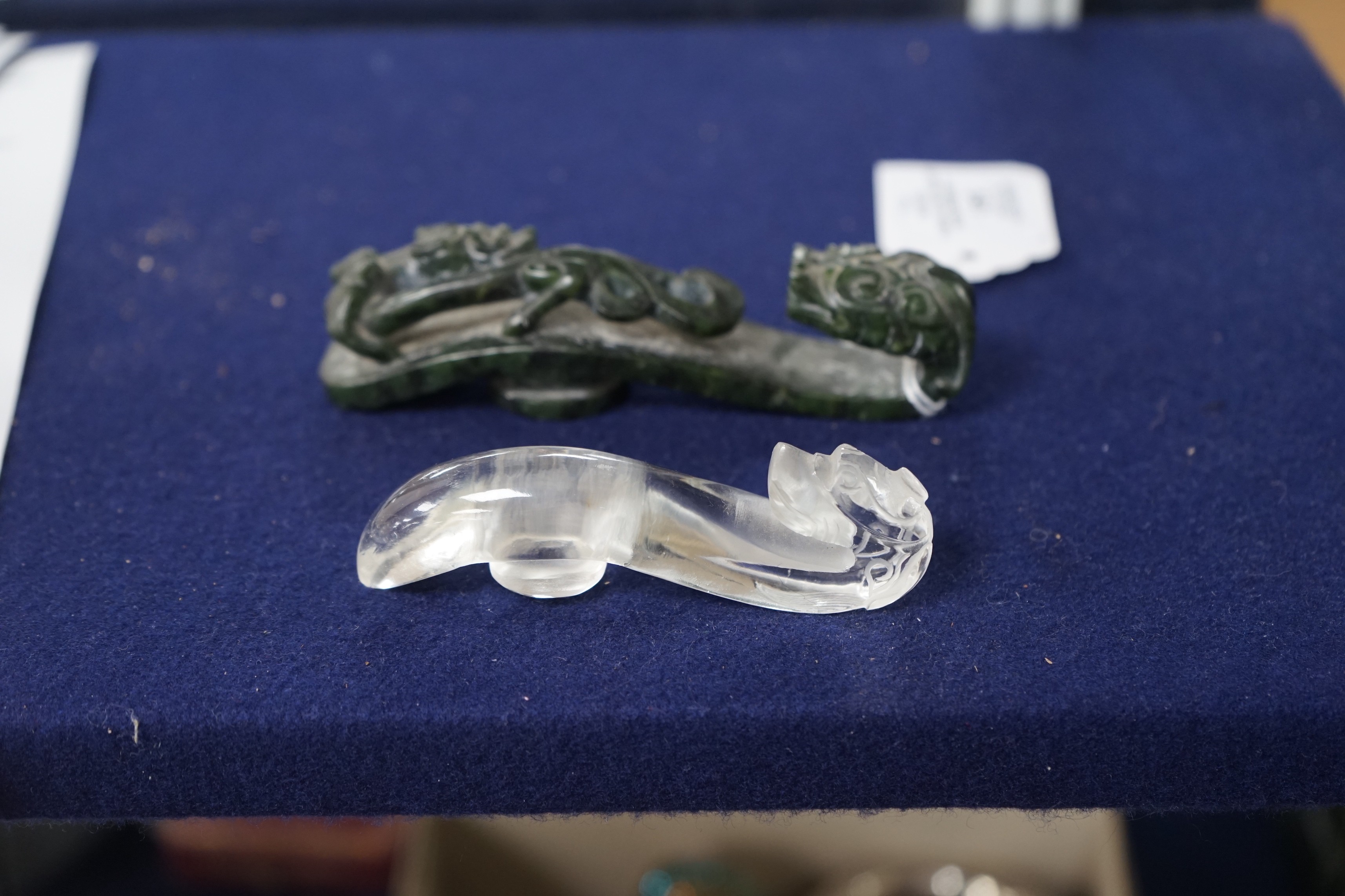 A Chinese rock crystal belt hook and a Chinese spinach green jade belt hook (2), largest 12cms long